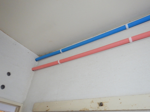 洋室の壁上部に配管